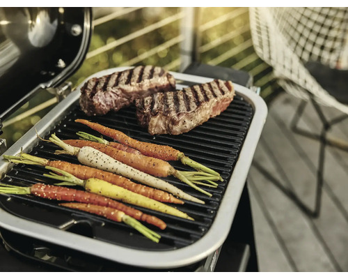 Barbecue avec steaks et carottes sur la grille
