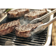 Steaks sur le gril avec une pince