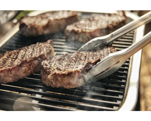 Steaks sur le gril avec une pince