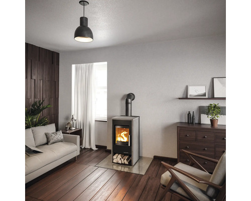 Salon avec poêle à bois, canapé, fauteuil, commode et décoration pour une ambiance chaleureuse