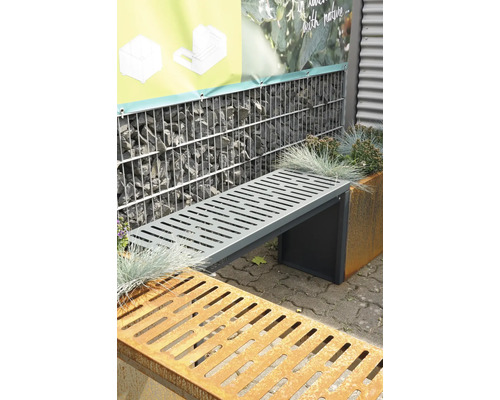 Graue Metallgartenbank vor Gabionenwand und Pflanzgefäß