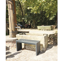 Szene im Freien mit einer Bank vor einem Steintrog