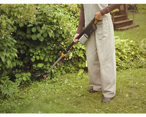 Une personne utilise une cisaille à gazon sans fil pour le jardinage