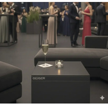 Szene mit Geiger-Tisch, Sektglas und Kerze bei einer Veranstaltung