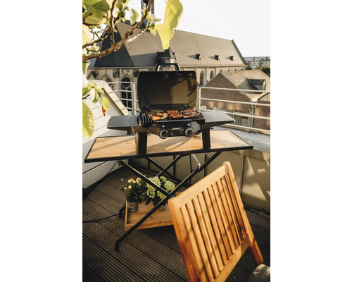 Barbecue à gaz sur un balcon avec table et chaise