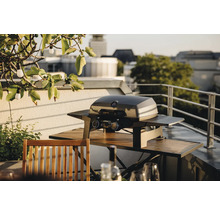 Gril à gaz sur un balcon avec une table et des chaises en bois