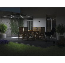 Parasol de jardin éclairé au-dessus d'un salon de jardin en bois et d'un barbecue sur une terrasse