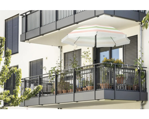 Vue d'un balcon avec store, parasol et plantes