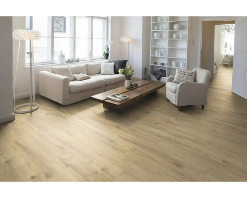 Salon avec parquet en bois clair, canapé, fauteuil et bibliothèque