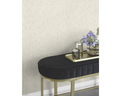Scène avec un papier peint texturé, un banc noir avec un cadre doré, un plateau doré avec des bougies et un vase de fleurs.