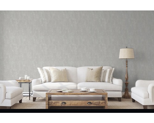 Salon avec canapé, fauteuil, table et lampadaire devant un mur gris