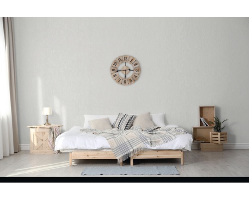 Chambre avec lit double, caisses en bois, lampe de table et horloge murale