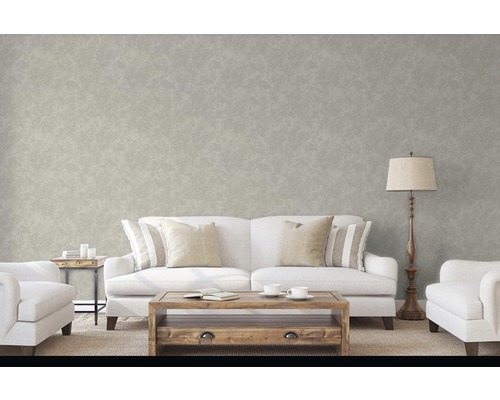 Salon avec canapé, fauteuil, table et lampadaire devant un mur à motifs