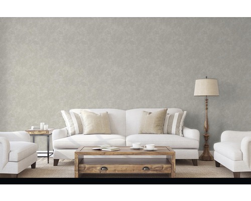 Salon avec papier peint, canapé, fauteuils, table basse et lampadaire.