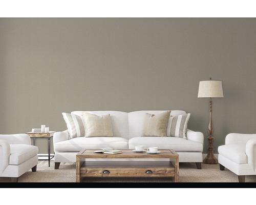 Salon avec canapé, fauteuil, table basse et lampadaire devant un papier peint structuré