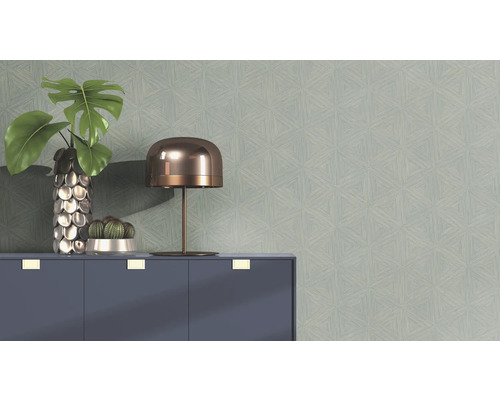Mur avec motif géométrique de papier peint, décoré d'une lampe de table, de plantes en pot et d'une armoire