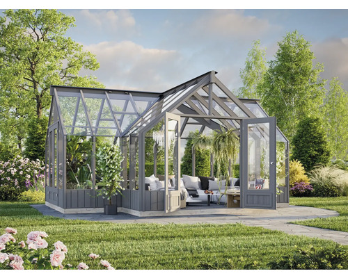 Serre avec murs en verre et portes doubles dans un jardin avec plantes et pelouse.