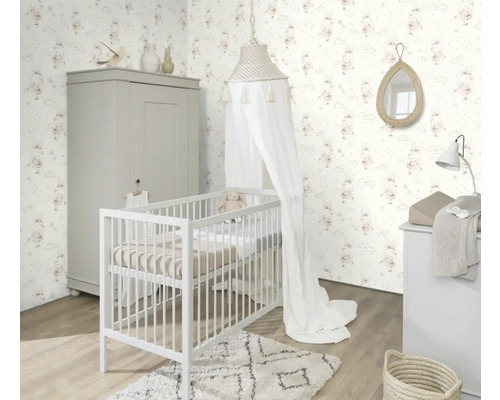 Chambre d'enfant lumineuse avec lit à barreaux, armoire, commode à langer et papier peint à motifs de lapins
