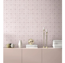 Vue d'une pièce avec papier peint à motifs roses avec couronnes, lettres et losanges