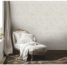 Scène avec papier peint beige à motifs floraux, méridienne avec coussins et couverture, et rideau
