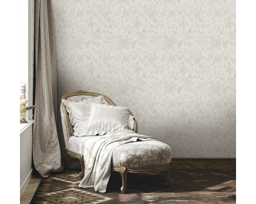 Scène avec papier peint beige à motifs floraux, méridienne avec coussins et couverture, et rideau