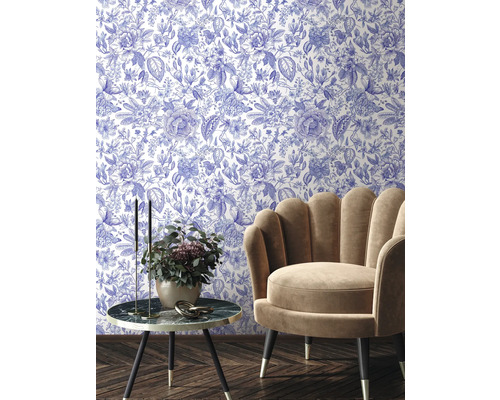 Aménagement intérieur avec papier peint à motifs floraux, fauteuil et table d'appoint