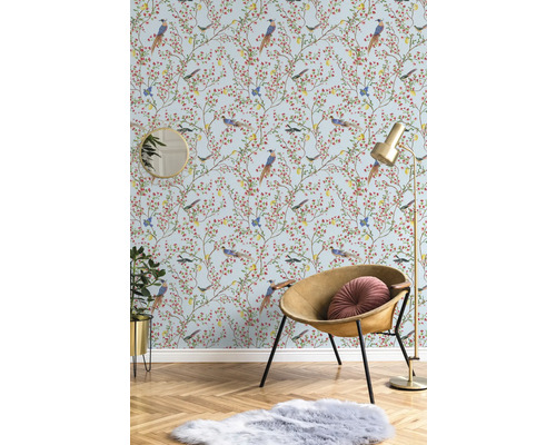 Pièce décorative avec papier peint à motifs d'oiseaux, fauteuil, lampadaire, miroir, plante d'intérieur et tapis