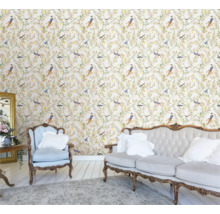 Intérieur clair et convivial avec papier peint floral à motifs d'oiseaux, canapé et fauteuil
