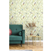 Vue d'une pièce avec un canapé en velours vert, une table d'appoint dorée et un papier peint à motif d'oiseaux