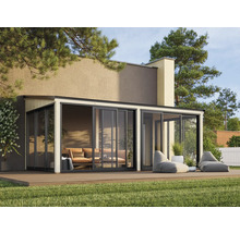 Pool house moderne avec portes coulissantes, terrasse et poufs dans le jardin.