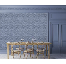 Salle à manger avec papier peint orné, table en bois et chaises.