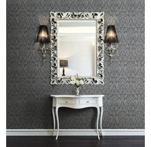 Décoration murale avec papier peint à motifs, miroir à cadre ornemental, appliques murales et console