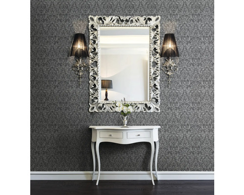 Décoration murale avec papier peint à motifs, miroir à cadre ornemental, appliques murales et console