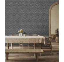 Salon décoratif avec papier peint à motifs derrière une table à manger et des chaises.