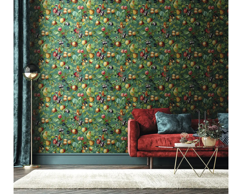 Salon avec papier peint aux fruits vert, canapé rouge et tapis