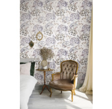 Chambre décorée avec lit, fauteuil, table d'appoint et papier peint fleuri