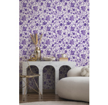 Vue d'une pièce avec du papier peint à motifs floraux en violet et blanc, une table avec des décorations et une chaise.