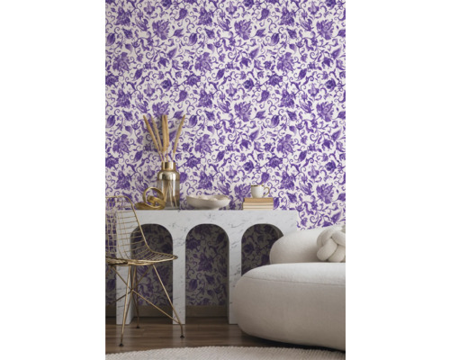 Vue d'une pièce avec du papier peint à motifs floraux en violet et blanc, une table avec des décorations et une chaise.