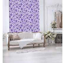 Salon décoratif avec papier peint à motifs floraux, canapé et cheminée.