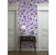 Vue d'une pièce avec papier peint à motifs floraux, commode et cadre de porte