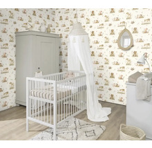 Chambre d'enfant avec lit à barreaux, commode à langer et armoire devant un papier peint à motifs d'animaux.
