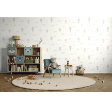 Chambre d'enfant avec étagère à jouets, fauteuil, table et jouets sur un tapis rond