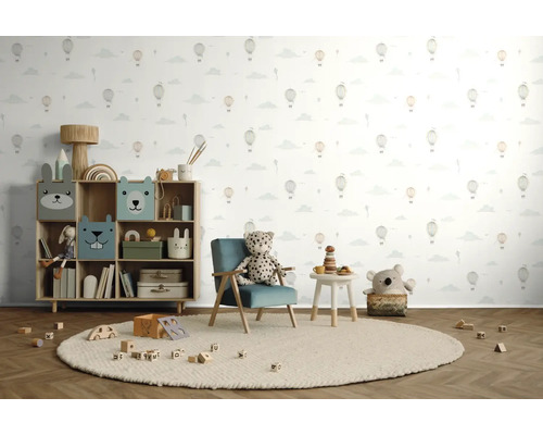 Chambre d'enfant avec étagère à jouets, fauteuil, table et jouets sur un tapis rond