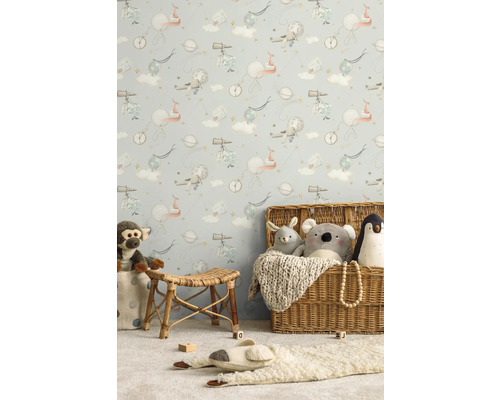 Chambre d'enfant avec papier peint sur le thème de l'espace, meubles en rotin et peluches