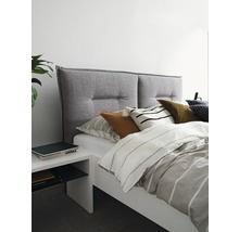 Lit avec tête de lit en tissu gris et table de chevet blanche