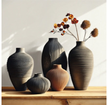 Groupe de vases cannelés de différentes tailles et formes sur une table en bois, certains avec des accents floraux.