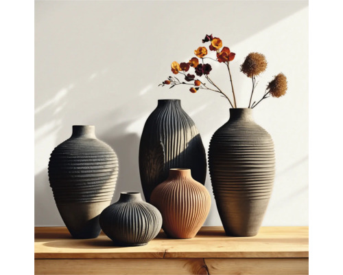 Groupe de vases cannelés de différentes tailles et formes sur une table en bois, certains avec des accents floraux.