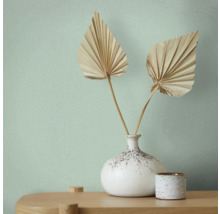 Papier peint avec motif textile, vase avec feuilles en éventail sur une table