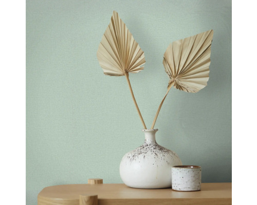 Papier peint avec motif textile, vase avec feuilles en éventail sur une table