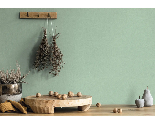 Mur clair et décoratif avec des accessoires tels que des fleurs séchées, une planche en bois avec des noix, une imitation de fruit et une plante en pot